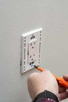 Close up of man installing electrical outlet in wall in room of house Stock Photos