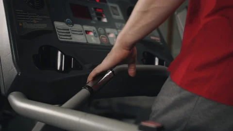 Close up of man jogging on treadmill at the gym and monitoring information he Stock Footage 106383910