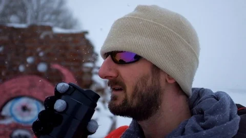 Close up of a man keeping warm in the snow Stock Footage 88437157