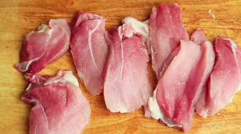 Close-up man in the kitchen is cutting pork on cutting board Stock Footage 65445026