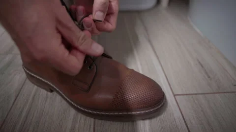 Close Up of Man Lacing Classic Brown Leather Shoes Видео 339503517