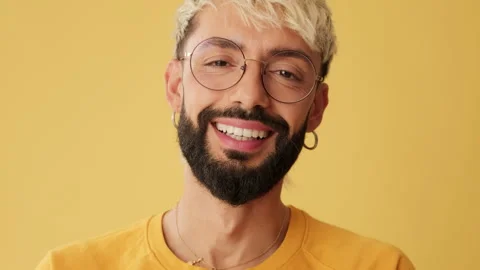 Close-up, man laughing looking at camera isolated on yellow background in studio Video stock 253935252