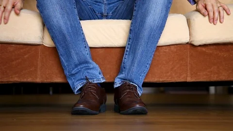 Close up of man leg sitting on sofa Stock Footage 129175000