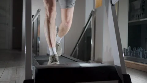 Close-up of Man Legs Running on Treadmill at Home. A man in sneakers and sh.. Stock Footage 332335043
