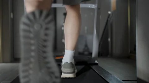 Close-up of Man Legs Running on Treadmill in Gym. Low angle shot of a perso.. Stock Footage 332335049