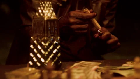 Close-up of Man Lighting Cigar over Money and Chess Table: Urban Noir Luxury Stock Footage 331834280