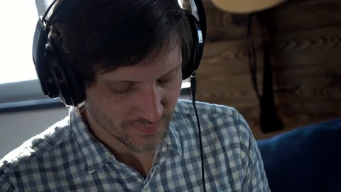 Close-up of a man listening to rhythmic pleasant music with headphones Stock Footage 105799854