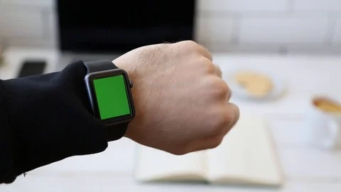 Close up of Man Looking at His Smart Watch With Green Screen on His Hand. Stock Footage 116613809