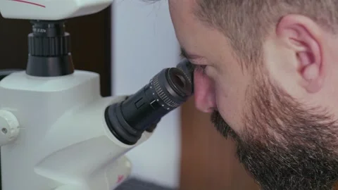 Close-up of a man looking into a microscope. Stock Footage 155090081