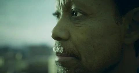 Close up of a man looking out over a city skyline during dusk Ilustração Stock