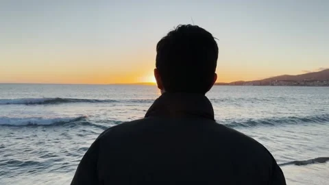 Close up of a man looking out to sea at sunset Stock Footage 304662719