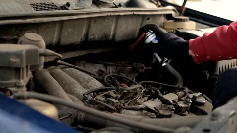Close up of man lubricating bolts under hood of car Stock-Footage 303072263