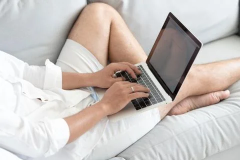 Close up man lying on sofa with laptop Stock Photos