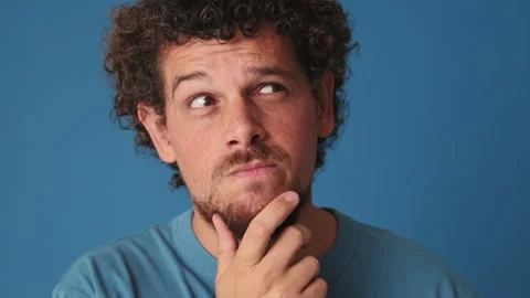 Close up, man making choice, having an idea, isolated on blue background in Stock Footage 250841120