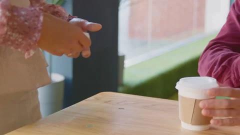 Close Up Of Man Making Purchase In Coffee Shop Using Debit Or Credit Card Stock Footage 164578945
