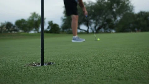 Close up of a man making a putt on a golf course green Stock Footage 115394994