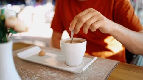 Close up of man male hands drinking coffee and mix sugar at spoon at cup mug in Stock Footage 218902363