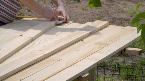 Close-up of a man marks planed boards with a pencil and tape measure Stock Footage 109066653