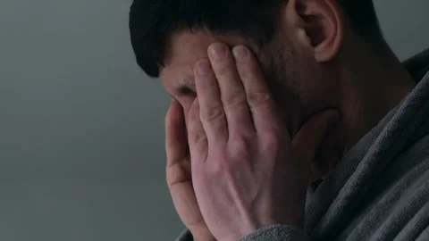 Close-up of man massaging temples while experiencing headache Видео 332055790