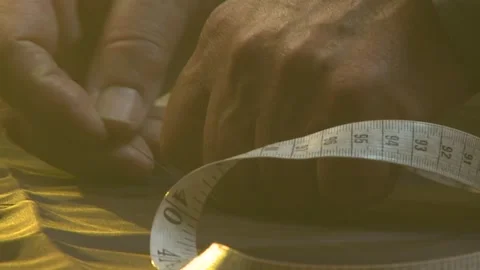 A Close-up of a man measuring fabric out with a tape measure Stock Footage 311924096