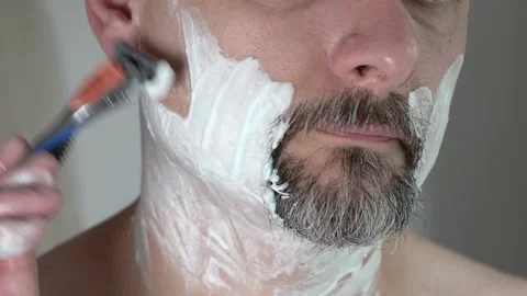 Close-up, a man of middle ages shaving his face with a razor, 4K Stock Footage 135882771
