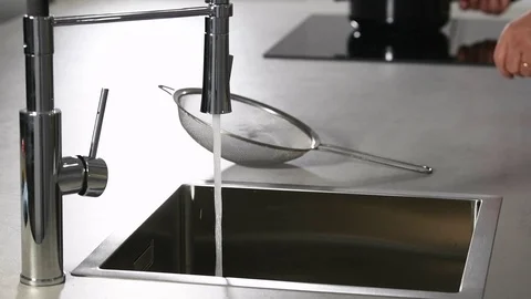 Close-up of a man moving white rice from a pot into a sieve and rinsing it wi Stock Footage 124246049