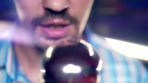 Close-up, a man with a mustache and a beard singing into a microphone on stage Stock Footage 161997188