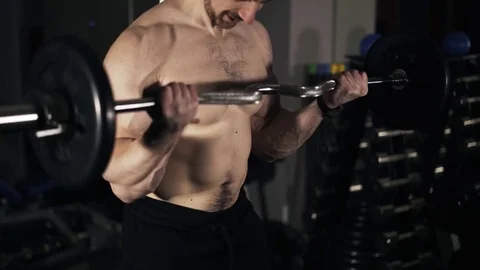 Close up of a man with naked torso doing a barbell exercise 動画素材 74276838