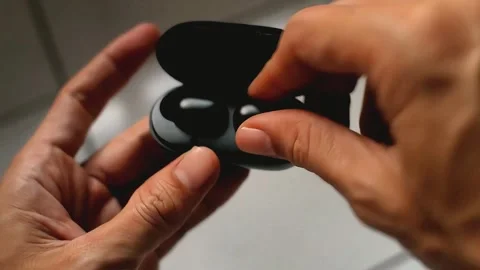 Close up of a man opening a black digital earphone Stock Footage 289696002