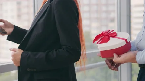 Close up man opening a box with a gift for a girl A woman who speaks on the Stock Footage 137266758