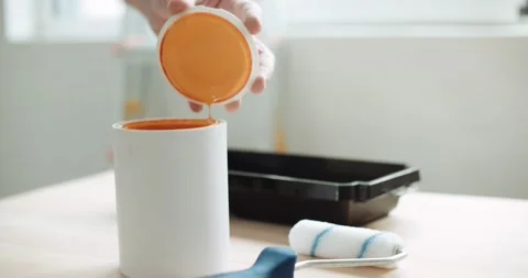 Close-up of a man opening a can of orange paint Stock Footage 155796522