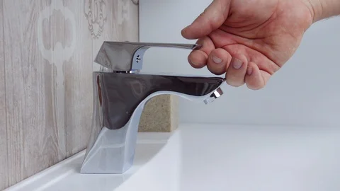 Close up of a man opening tap at the bathroom sink Stock Footage 127890083