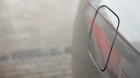 Close-up man opens the gas tank flap and inserts fuel nozzle in car's gas tank Video stock 116369002