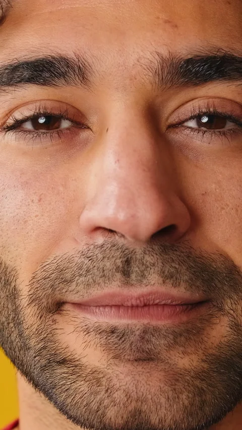 Close-up, man opens his eyes smiling and looking at camera isolated on yellow Stock Footage 264541912