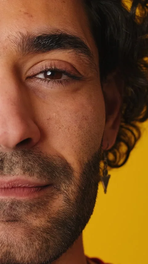 Close-up, man opens his eyes smiling and looking at camera isolated on yellow Stock Footage 265178809