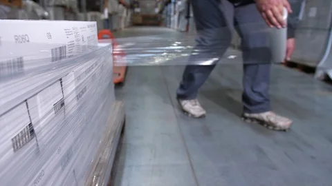 Close-up. A man is packing a pallet with boxes with plastic wrap. 4K Slow Mo 库存影片 111768422