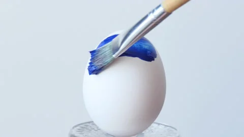 Close-up of a man painting Easter eggs with a special brush Ukrainian flag Stock Footage 172106677
