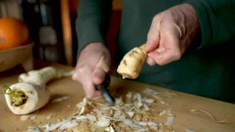 Close up of a man peeling a parsnip with a vegetable peeler in slow motion Stock Footage 146000345