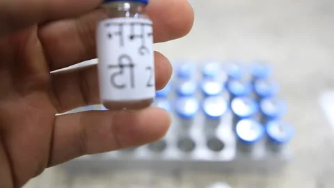 A close up from a man picking up a vial with a liquid labelled as sample in hind Stock Footage 254600653