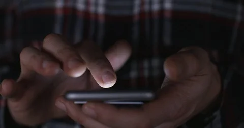 Close up of man in placing a bet on mobile phone at night with fingers crossed. Vídeos de archivo 89852606