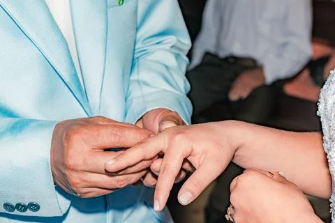 Close-up of a man placing the wedding ring on his bride Stock Photos