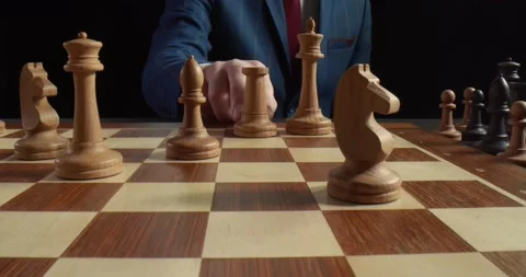 Close up of man playing chess and making move with white rook isolated on black Video stock 136885782