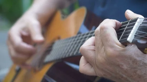 Close up of man playing chords and finger picking on acoustic guitar Stock Footage 78614328