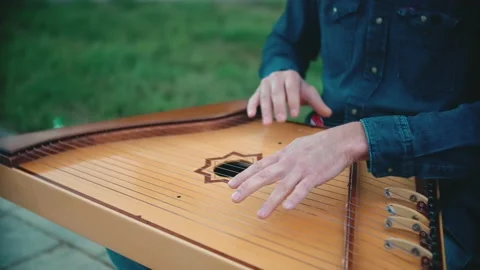 Close-up of a man playing a folk instrument playing the harp. Stock Footage 148880504