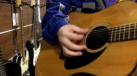Close up man playing guitar inside store Stock Footage 58607311