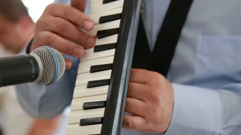 Close-up of a man playing on the musical instrument MELODICA Video stock 99366641