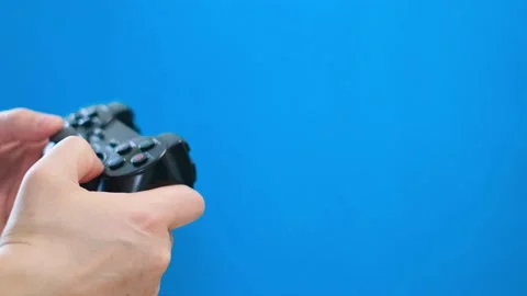 Close-up of a man playing on a portable game console on a blue background Stock Footage 233895572