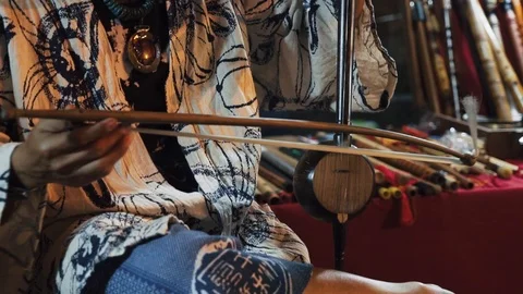 Close up of a man playing saw sam sai,  a traditional bowed string Stock Footage 102067087
