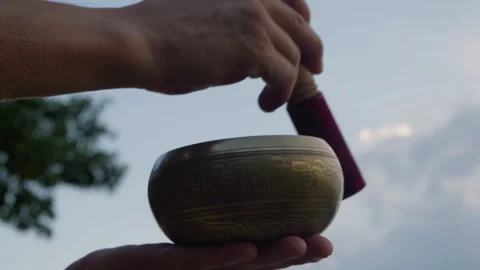 Close-up, man playing a Tibetan singing bowl against the background of the Stock Footage 276111490