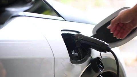 Close up Man plugging an electric car or EV at home. Stock Footage 321757418